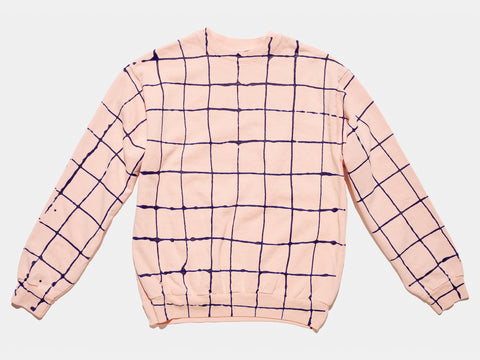 100% cotton pink sweatshirt, perfectly cut, with hand-painted, drippy blue grid extending across body and down sleeves. Painterly drips perfect the imperfect composition. The pattern continues on the other side of the shirt.
