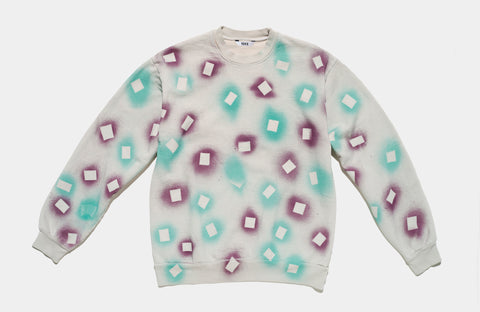 100% cotton grey/cement sweatshirt, perfectly cut, with hand-painted, purple and teal negative cut-out squares extending across body and down sleeves. The pattern continues on the other side of the shirt.