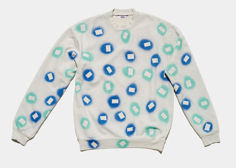 100% cotton grey/cement sweatshirt, perfectly cut, with hand-painted, blue and teal negative cut-out squares extending across body and down sleeves. The pattern continues on the other side of the shirt.