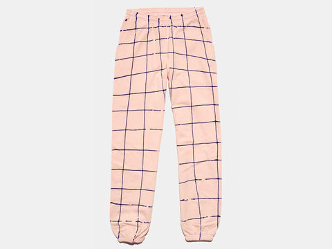 100% cotton pink sweatpants, perfectly cut, with hand-painted, drippy blue grid extending across body and down both legs. Painterly drips perfect the imperfect composition. The pattern continues on the other side of the pants. 